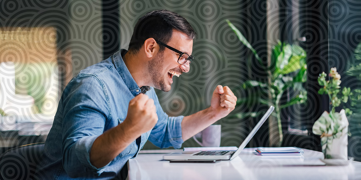 A man excited in front of his computer