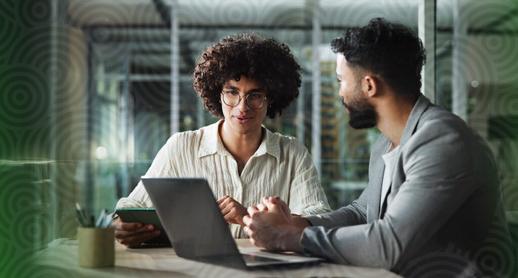 Two people looking at planning software on a computer.