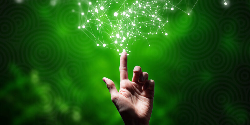 Index finger pointing upward against a green background and white sparks are coming out of finger.