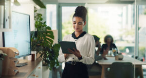 Businesswoman holding and analyzing report on her tablet.