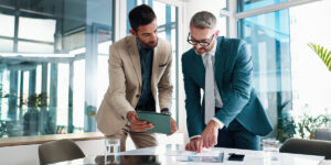 Financial advisor and client looking over reports on a computer