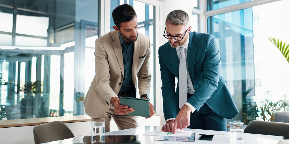 Financial advisor and client looking over reports on a computer